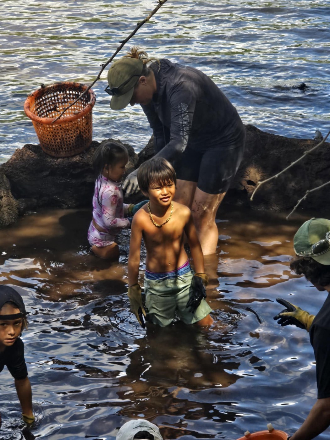 Children and adults learning at the fishpond