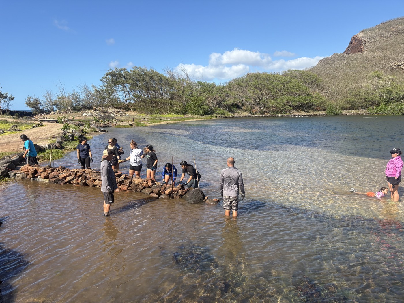 Community members restoring the fishpond wall